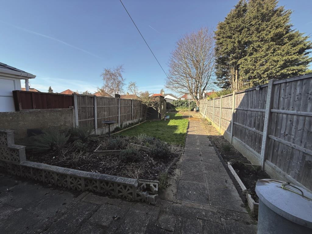 Lot: 109 - THREE-BEDROOM TERRACE HOUSE FOR IMPROVEMENT AND REFURBISHMENT - Patio area with path leading to end of garden with lawn area